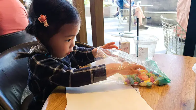 child taking candy out of the bag